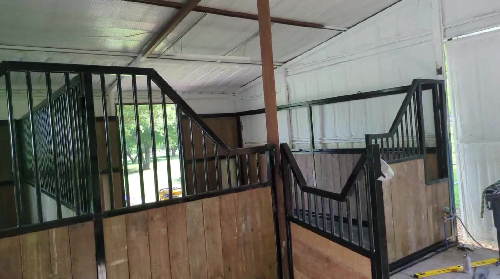 New black steel stall fronts with stepped yokes being installed in the barn