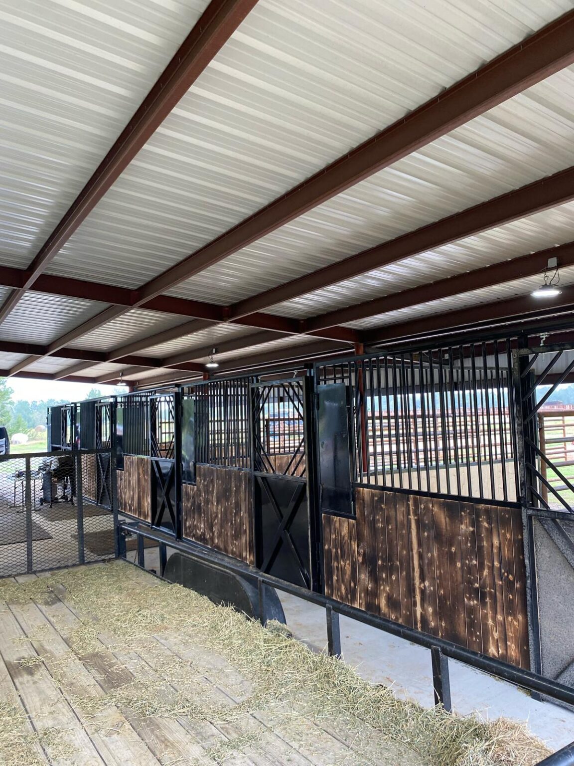 Long row of stalls under an open pavilion with dark wood infill