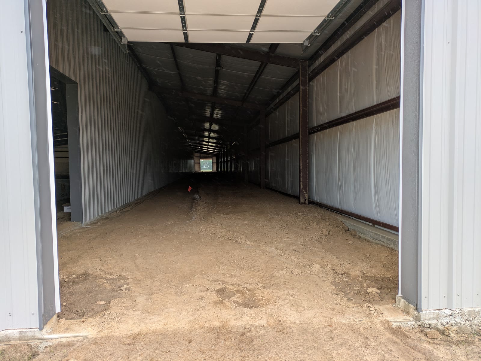 Empty steel building with a dirt floor before the stalls were installed