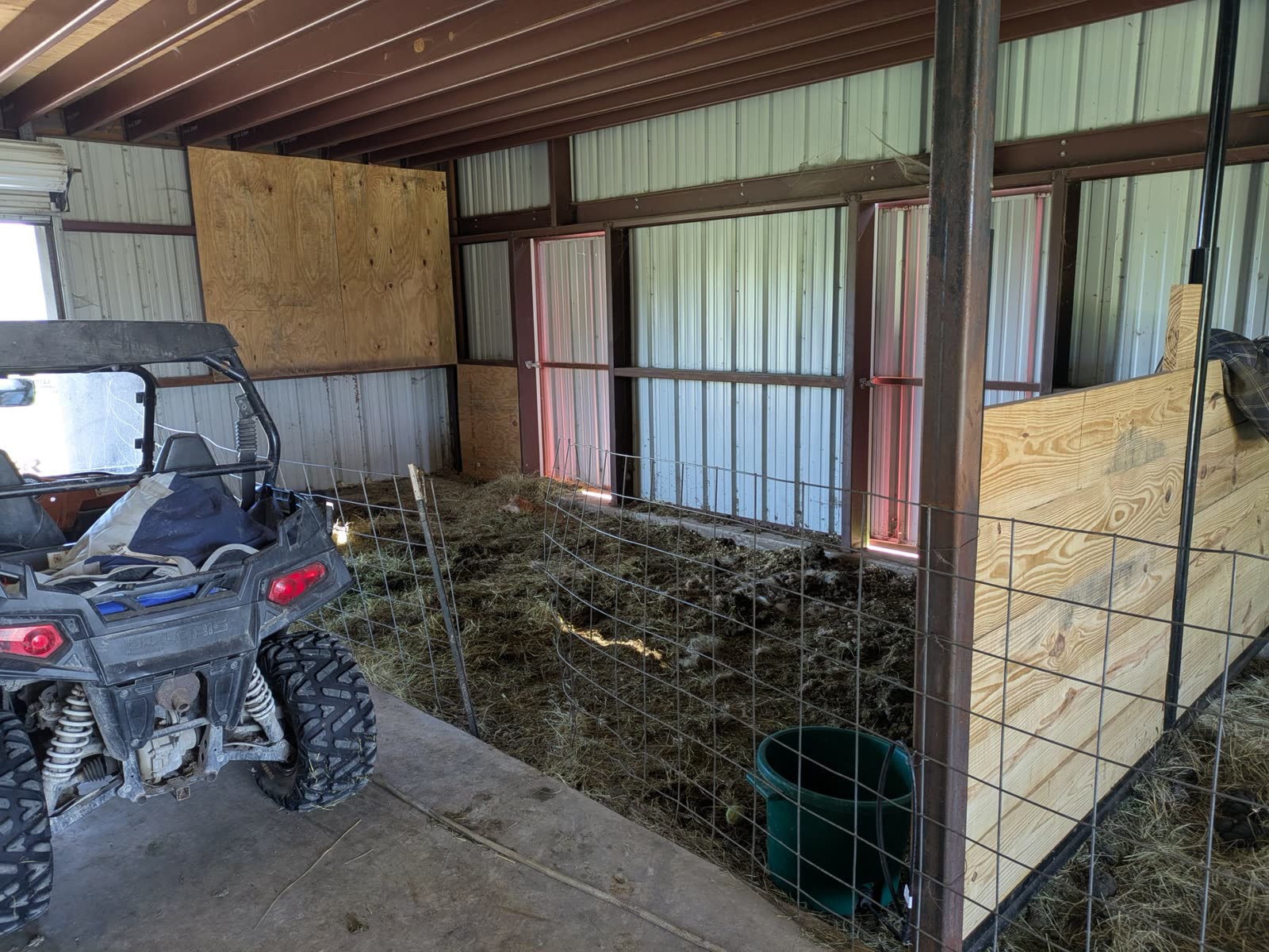The same corner before the build: dirt-floor pens fenced with wire panels
