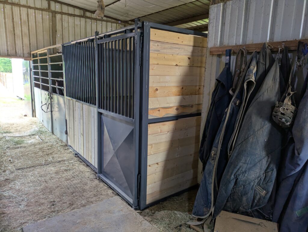 Sliding stall door with X-brace panel and tack wall beyond